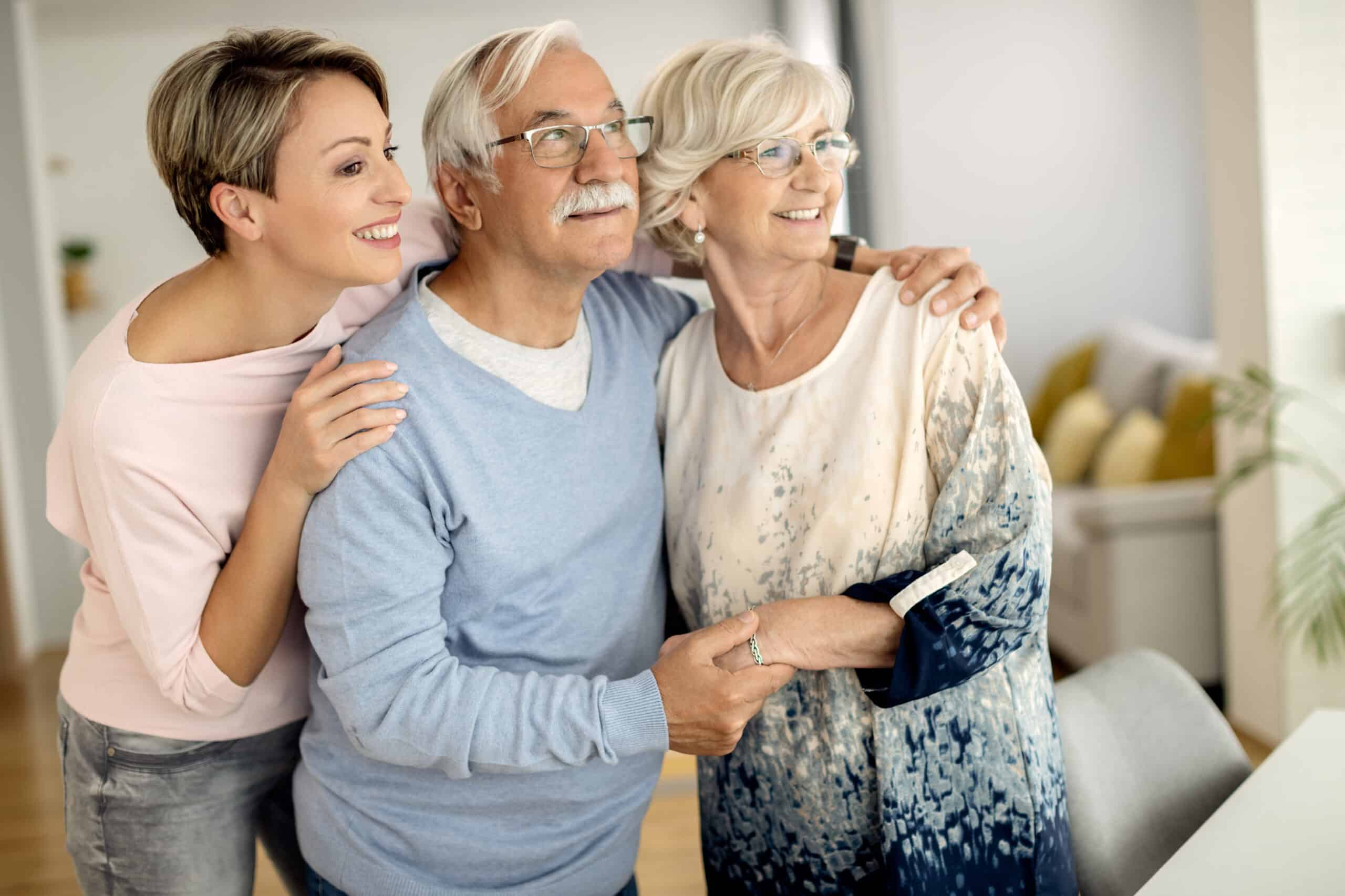 happy woman and her senior parents embracing scaled